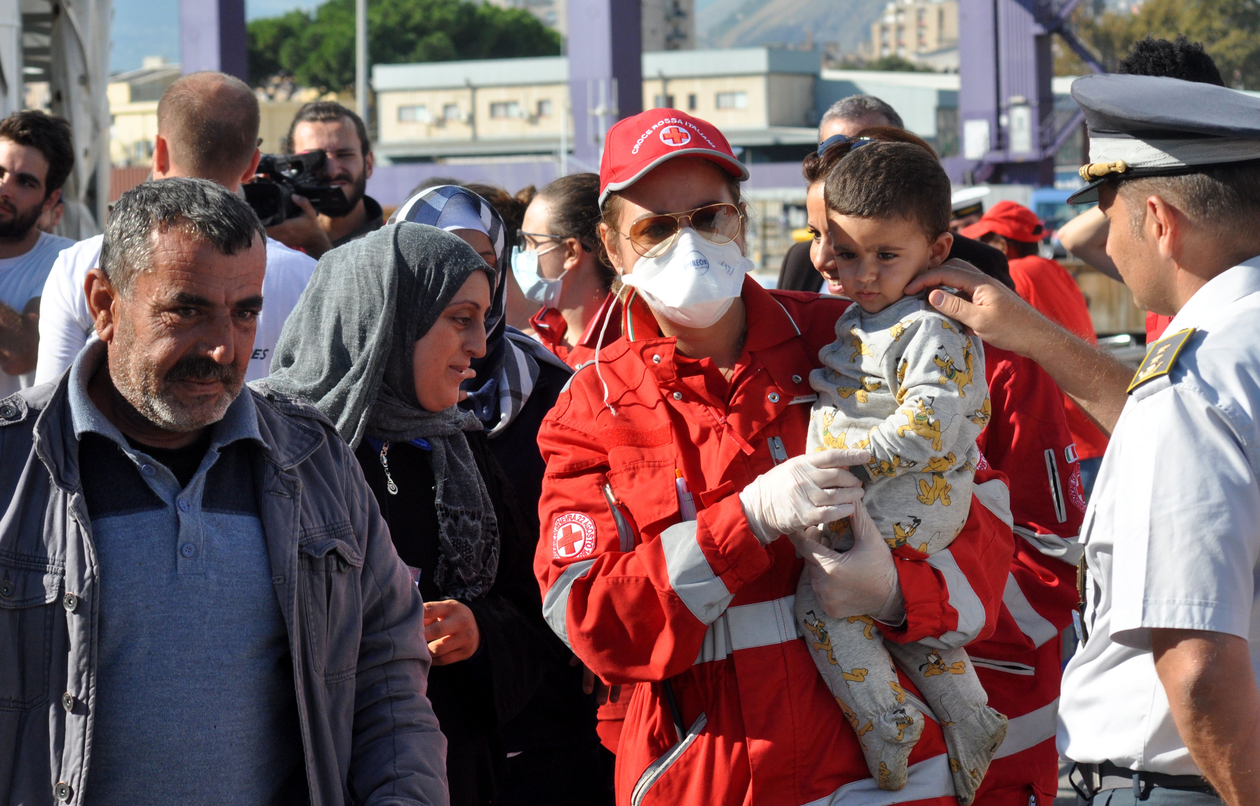 عامل من الصليب الأحمر يحمل طفل