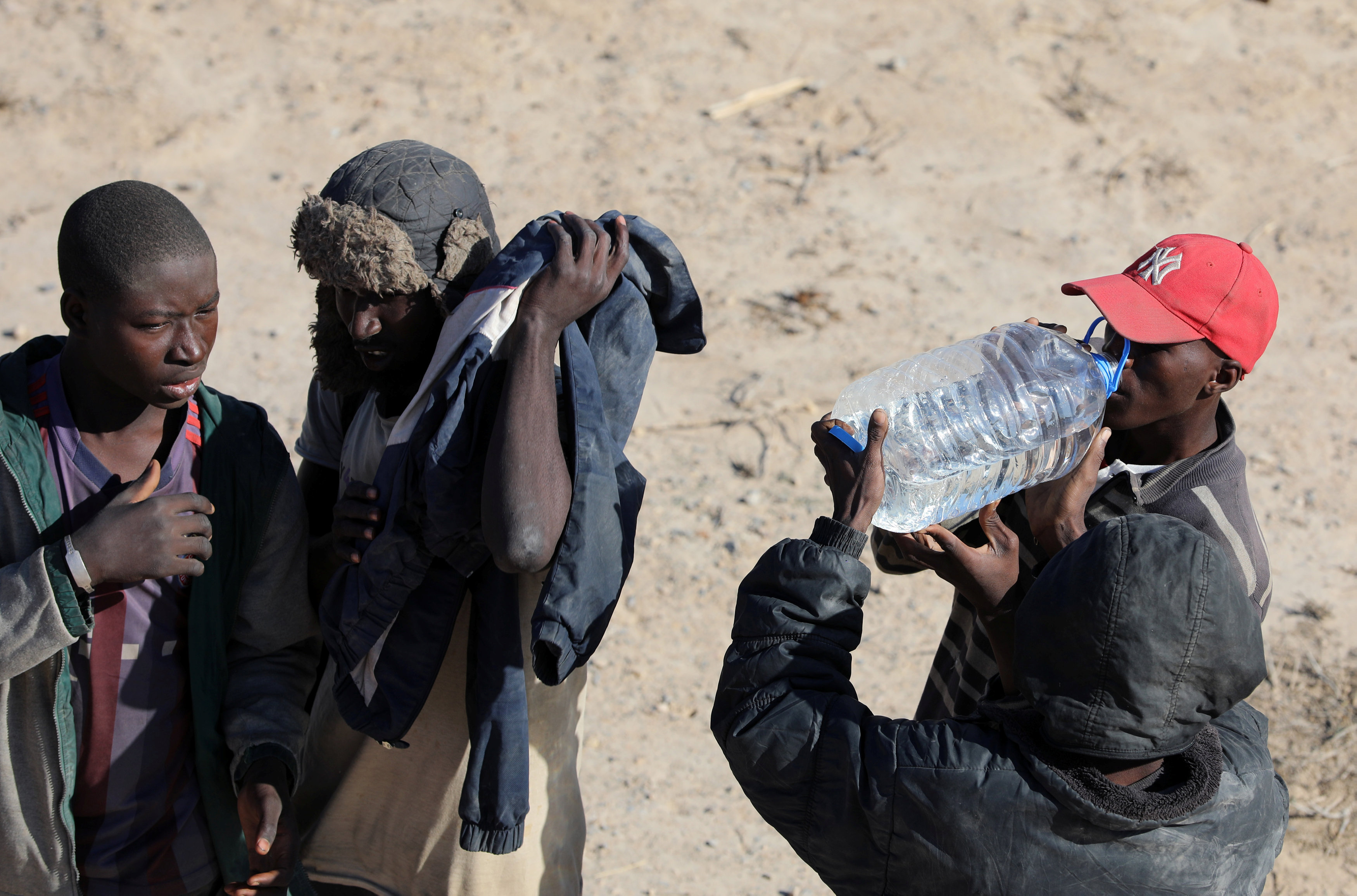 مهاجرون غير شرعيون يشربون المياه فى ليبيا