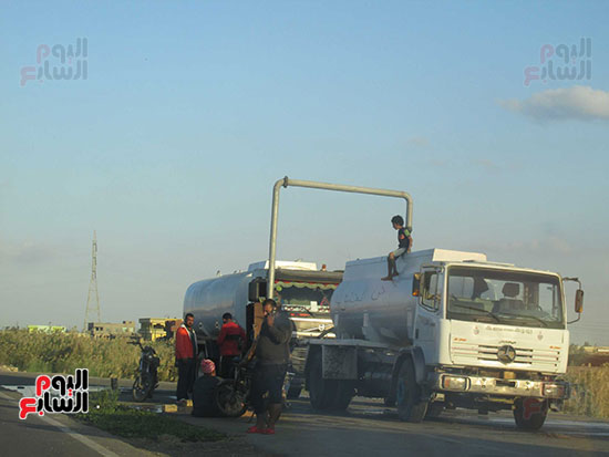 طفل يتابع ملء خزان السيارة للتحرك