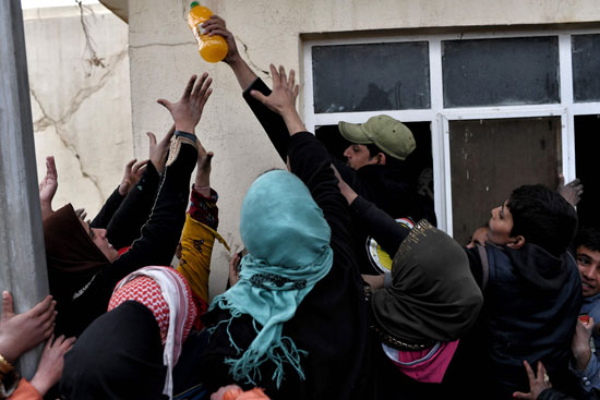 جندى عراقى يسلم مساعدات غذائية للنازحين من الموصل جندى عراقى يسلم مساعدات غذائية للنازحين من الموصل