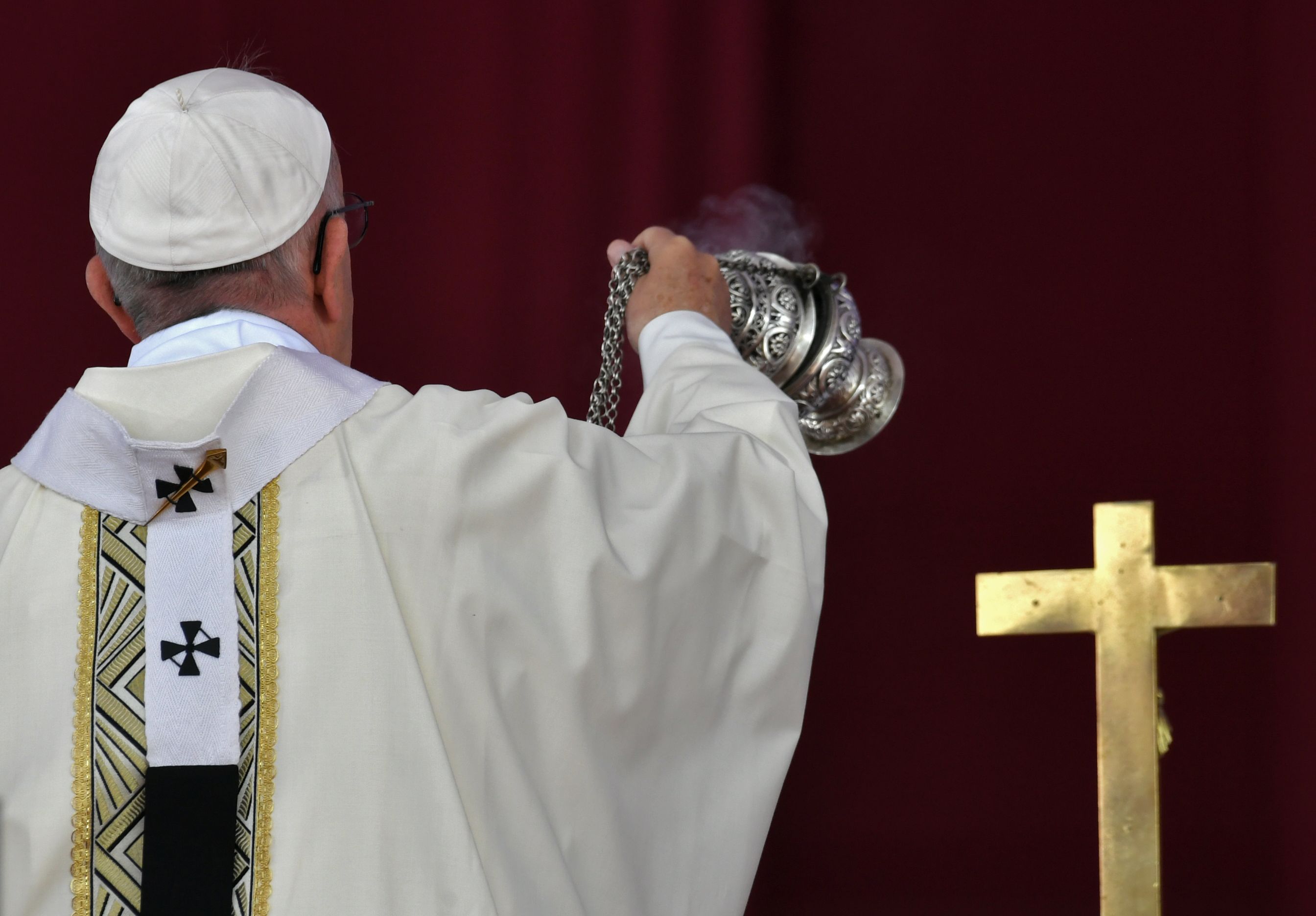 بابا الفاتيكان يحمل مبخرة ويقف أمام الصليب