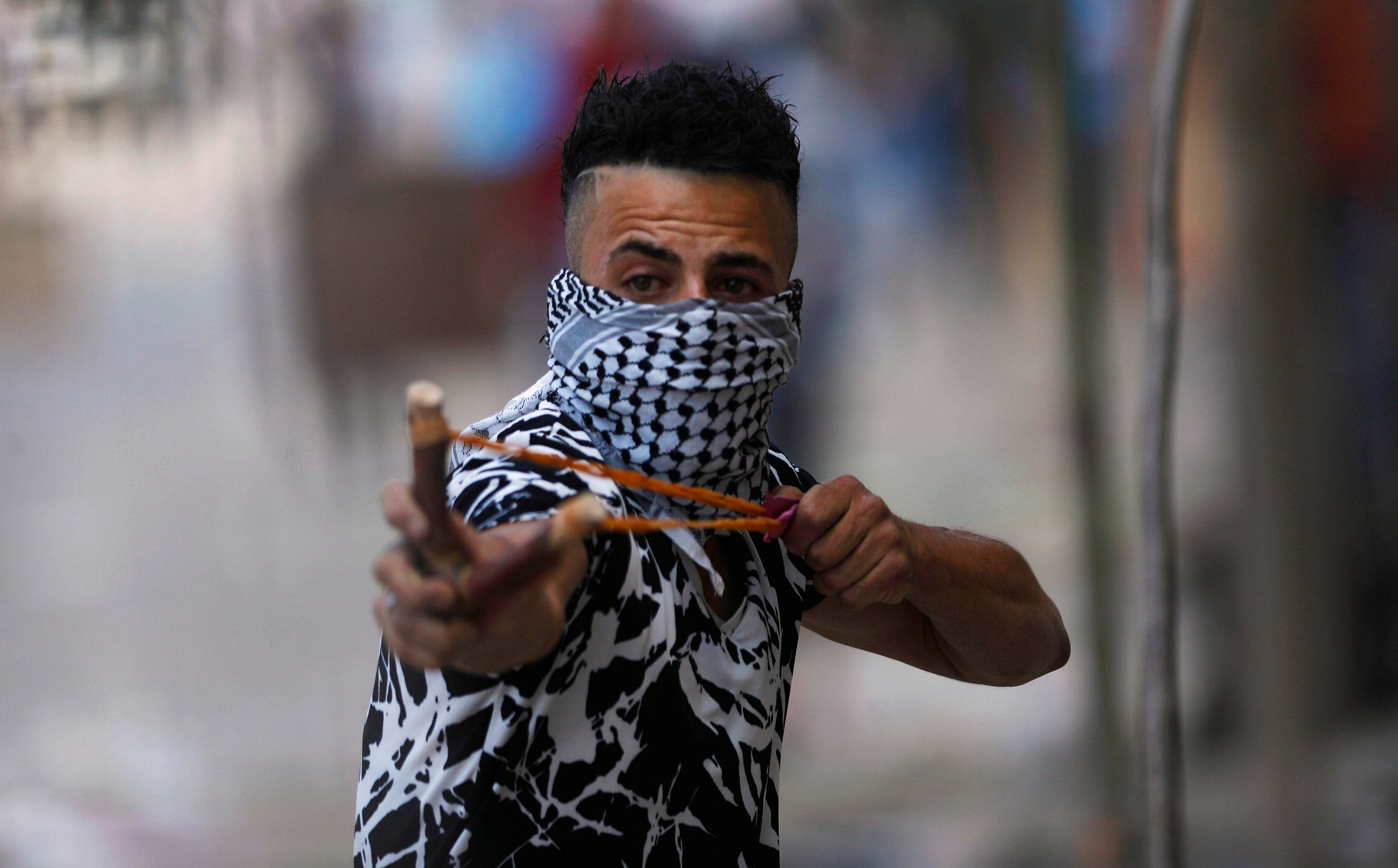 متظاهر فلسطينى يستخدم( نبلة ) ضد قوات الإحتلال
