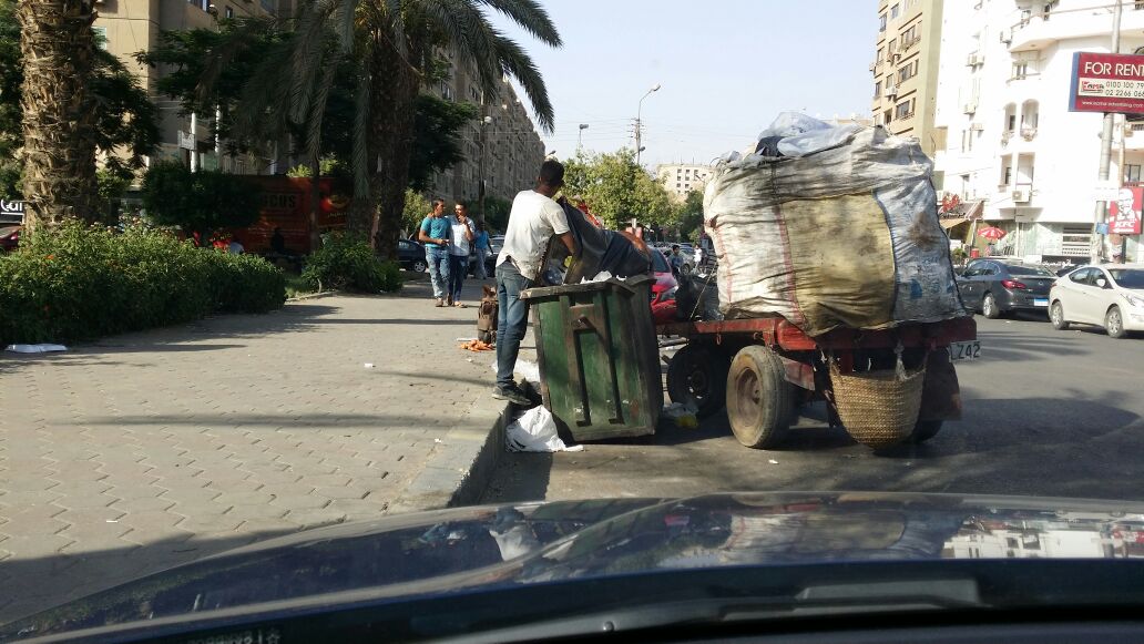 احد العمال يقوم بتنقية القمامة