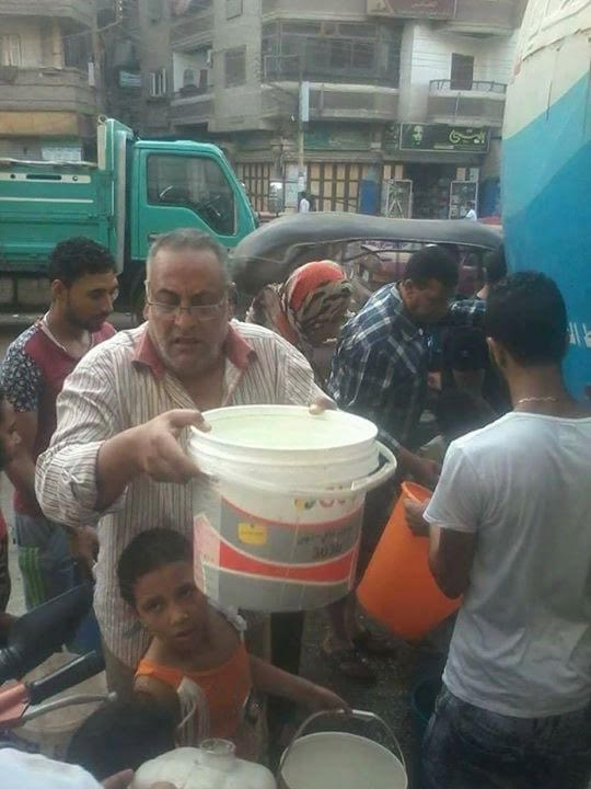 أحد المواطنين يحمل جردل لملئة من عربات مياه الشرب