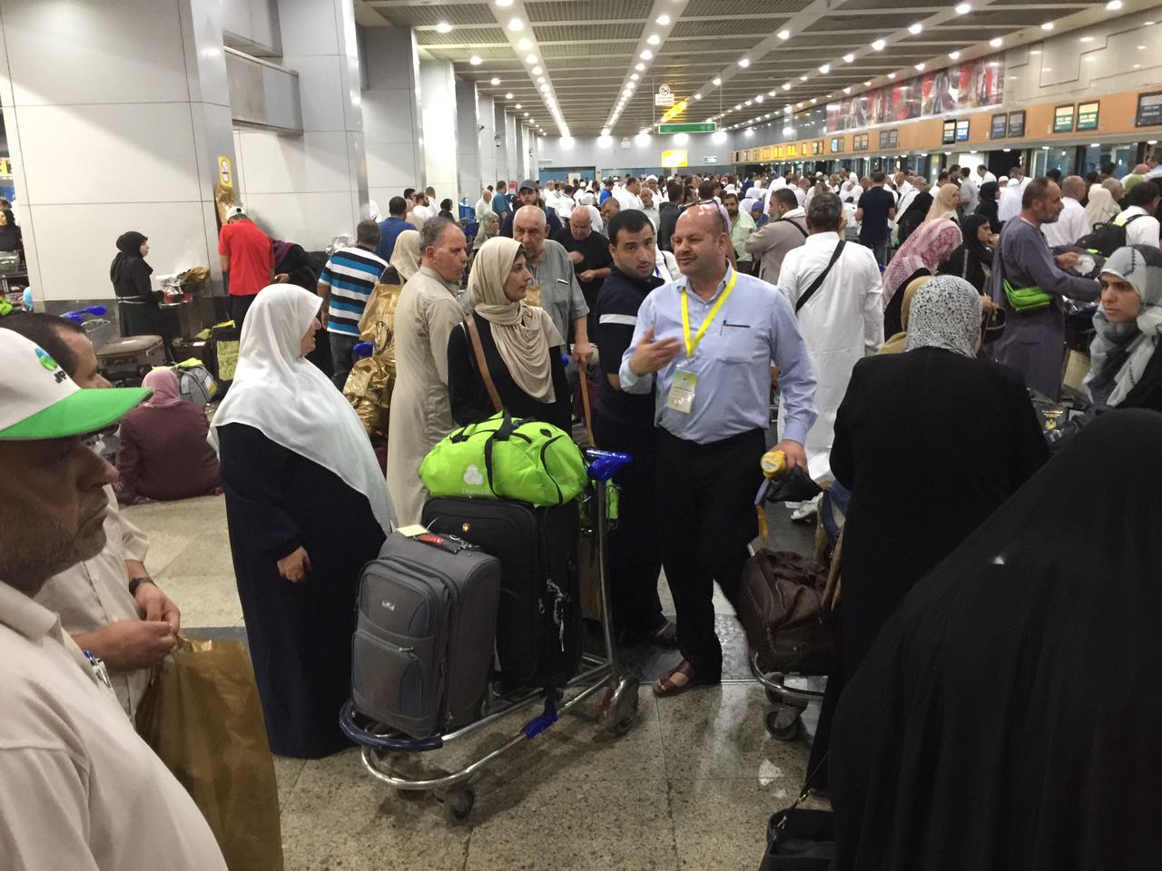 أحد مسئولو المطار يطمئن حجاج فلسطين علي سير إنهاء إجراءات سفرهم