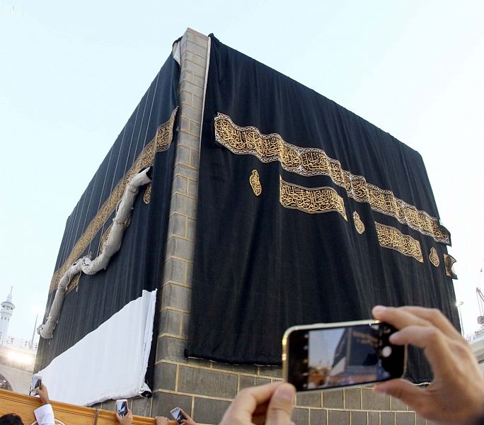 حاج يصور مراحل تغيير كسوة الكعبة بهاتفه المحمول