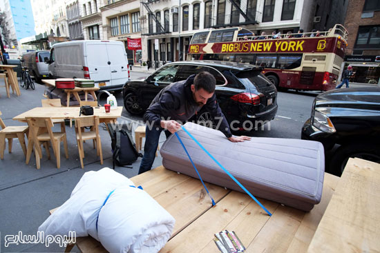 الفنان يقوم بفرد السرير على أحد الأرصفة -اليوم السابع -10 -2015