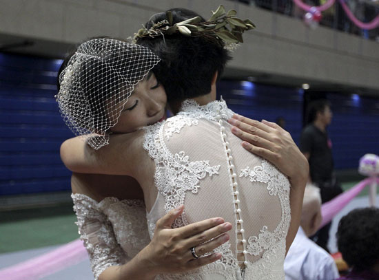 عروستان مثليتان يحتضنان بعضهما أثناء حفل زفافهما  -اليوم السابع -10 -2015