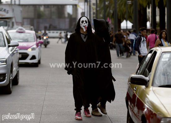 شخصان يرتديان الأقنعة فى مهرجان مكسيكو سيتى  -اليوم السابع -10 -2015