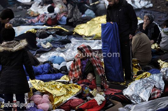 اللاجئون يحاولون الاحتماء من البرد القارس  -اليوم السابع -10 -2015