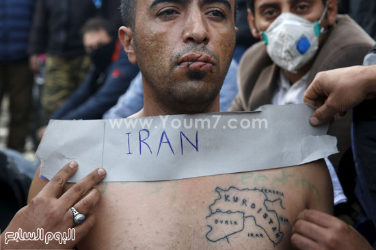 متظاهر يرفع لافتة تحمل اسم بلاده ويرسم خريطتها على جسده -اليوم السابع -11 -2015