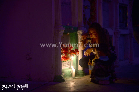 إحدى المشاركات فى الاحتفال بعيد القديسين وهى تضىء الشموع -اليوم السابع -11 -2015