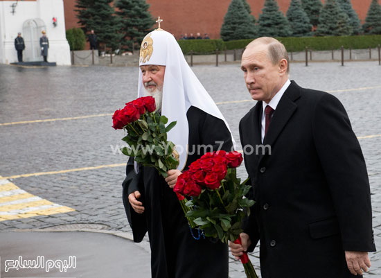  بوتين يحمل باقة ورود وإلى جانبه البطريرك كيريل -اليوم السابع -11 -2015