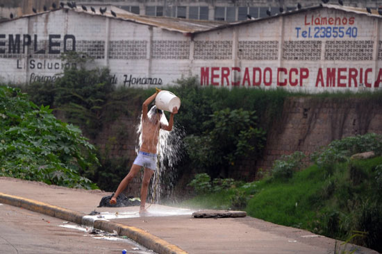 شاب يسكب المياه الكثيرة على نفسه أثناء دورة ألعاب سكانى الشوارع فى مدينة 