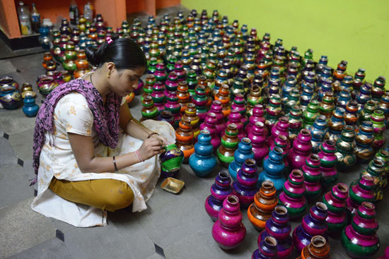 فنانة هندية تزين أطباق الفخار بالألوان استعدادا لمهرجان 