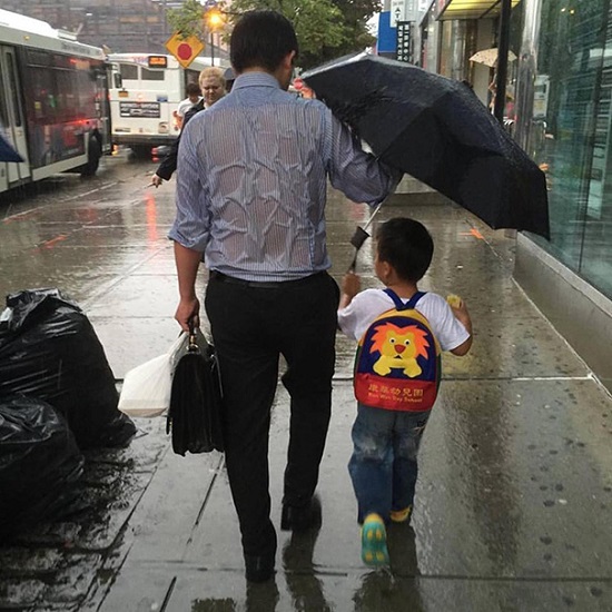 اب مثالى يحمى ابنه من ماء المطر ولا يكترث لحاله -اليوم السابع -1 -2016