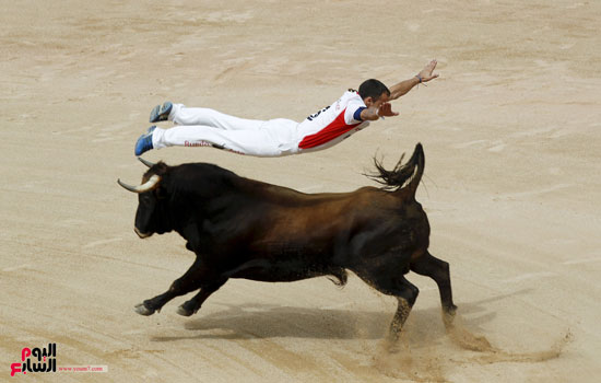  أحد مزارعى الثيران يقفز فوق ثوار خلال مسابقة فى بامبيلونا بإسبانيا -اليوم السابع -12 -2015
