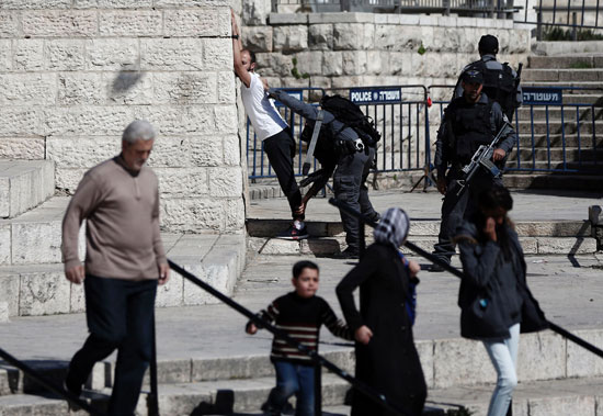 شرطى إسرائيلى يفتش طفلا فلسطينيا عند باب العامود (2)