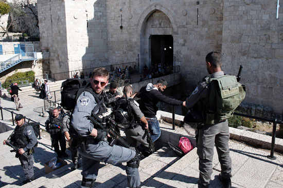 شرطى إسرائيلى يفتش طفلا فلسطينيا عند باب العامود (3)