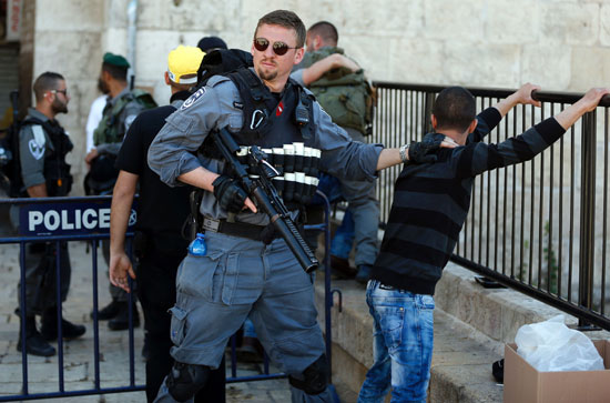 شرطى إسرائيلى يفتش طفلا فلسطينيا عند باب العامود (4)