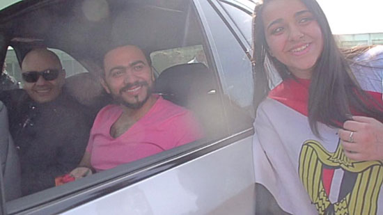 	تامر حسنى داخل السيارة وبجانبه فتاة تحمل علم مصر  -اليوم السابع -4 -2015