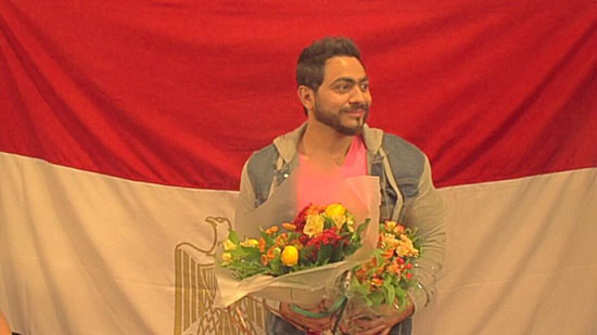 	تامر يحمل باقات من الورود وخلفه علم مصر  -اليوم السابع -4 -2015