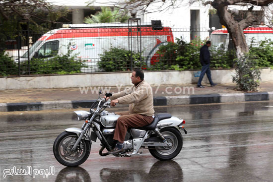  شخص يسير بدراجته البخارية وسط الأمطار -اليوم السابع -4 -2015