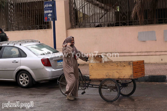  بائع يحاول اللجوء إلى مكان يقيه الأمطار  -اليوم السابع -4 -2015