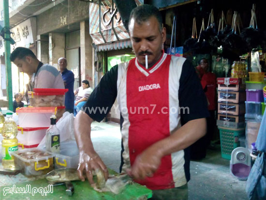  احد البائعين اثناء قيامهم بتنظيف سمك الرنجة والفسيخ -اليوم السابع -4 -2015