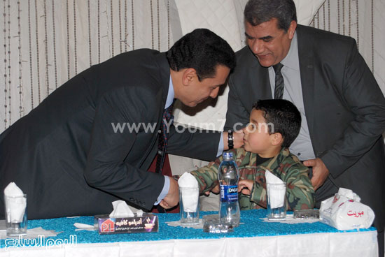  المحافظ يصافح ابن أحد الشهداء خلال التكريم  -اليوم السابع -4 -2015