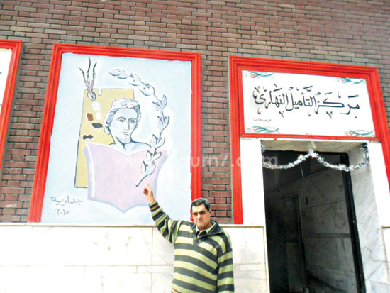 أحمد يشير إلى جدارية رسمها أمام مبنى التأهيل -اليوم السابع -4 -2015