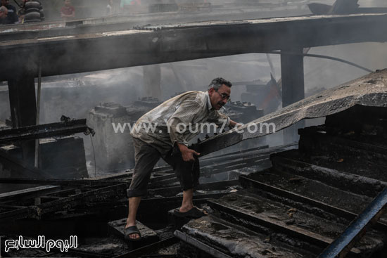 	أحد المواطنين يرفع أنقاض النيران  -اليوم السابع -4 -2015
