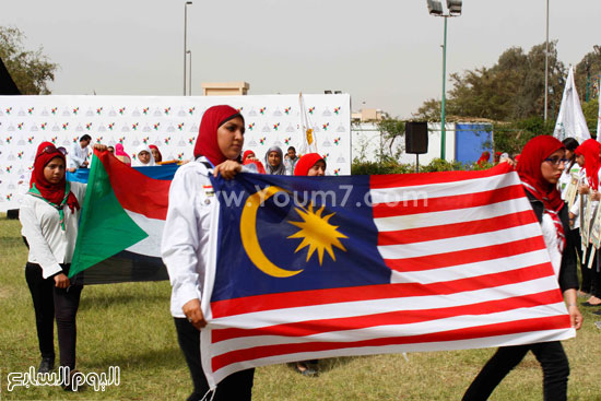  طلاب عين شمس يحملون أعلام الدول المشاركة بالمهرجان -اليوم السابع -4 -2015