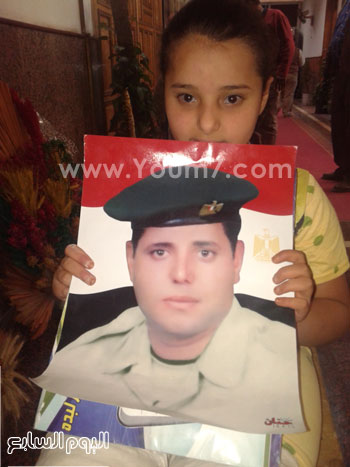 الطفلة تحمل صورة والدها الذى كان فى القوات المسلحة -اليوم السابع -4 -2015