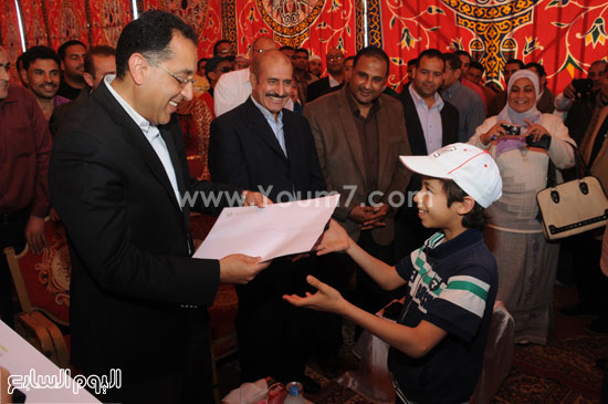 وزير الإسكان يسلم أحد الأطفال عقد الوحدة السكنية الخاص بأسرته  -اليوم السابع -4 -2015
