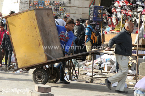  عامل يجر صناديق حفظ البضائع لإخلاء الميدان  -اليوم السابع -4 -2015