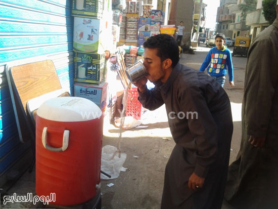   مواطن يفرغ المياه من كلمن فى الشارع  بعد خوفه من مياه الحنفية -اليوم السابع -4 -2015