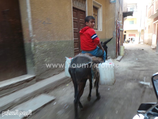 طفل يصل منزله وسط فرحه بالحصول على المياه النقية. -اليوم السابع -4 -2015