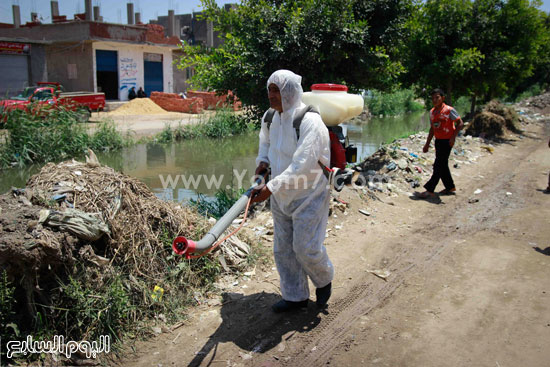 عمال النظافة يعقمون الترعة قبل وصول المحافظ بدقائق -اليوم السابع -5 -2015