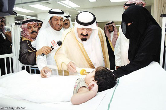 الملك عبد الله يقوم بوضع زجاجة اللبن فى فم طفل صغير  -اليوم السابع -5 -2015