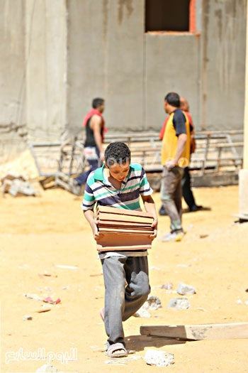 	طفل يحمل ألواح من الخشب بمشروعات الإسكان الجديدة -اليوم السابع -5 -2015