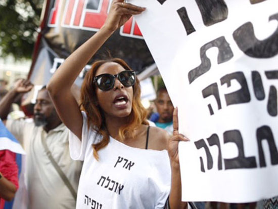 	إثيوبية تحمل لافتة بعنوان إسرائيل أرض العنصرية  -اليوم السابع -5 -2015