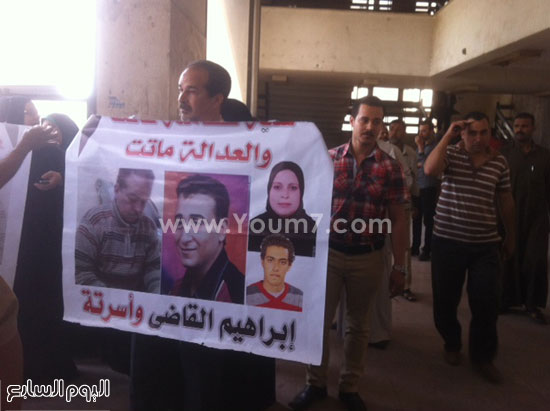 أحد أقارب الضحايا يرفع صورتهم -اليوم السابع -5 -2015