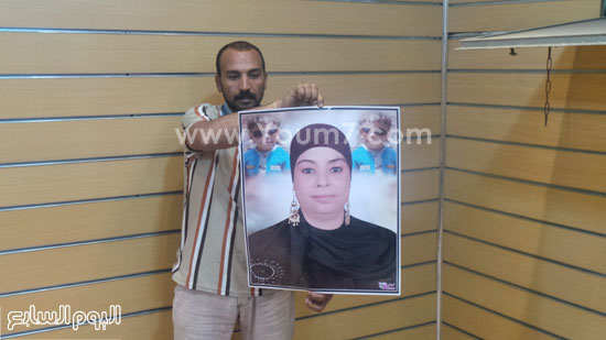 صورة شقيق المجنى عليها وهو يحمل صورة شقيقته     -اليوم السابع -5 -2015