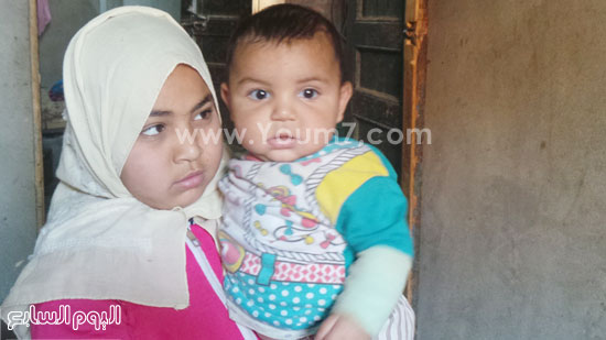  هاجر ابنة الشهيد الكبرى تحمل شقيقها الأصغر محمد (5 أشهر) -اليوم السابع -5 -2015