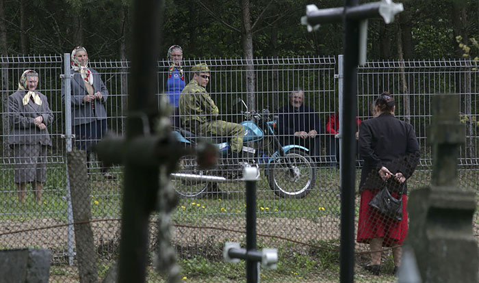  امرأة تقف تتحدث مع أقاربها عبر السياج على الحدود بين بيلاروسيا وليتوانيا -اليوم السابع -5 -2015