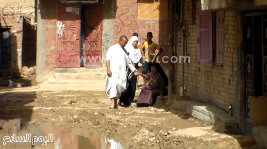 2-	شاب يحمل والدته المسنة لعبور الشارع بعيدًا عن مياه الصرف -اليوم السابع -5 -2015