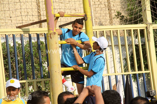 	شابان يتسلقان أحد الأسوار لمتابعة المباراة  -اليوم السابع -5 -2015