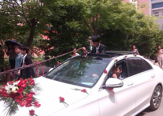 أحد راكبى السيارة يتحكم فى الحبل الذى يربط العريس -اليوم السابع -5 -2015