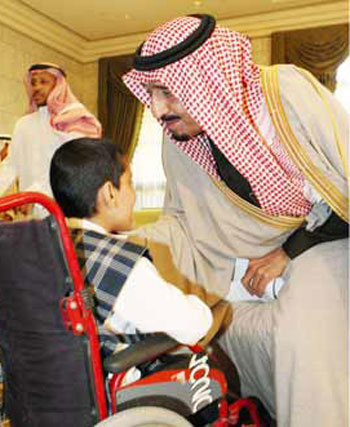 الملك سلمان بن عبد العزيز خادم الحرمين الشريفين يداعب طفلا من ذوى الاحتياجات الخاصة  -اليوم السابع -5 -2015